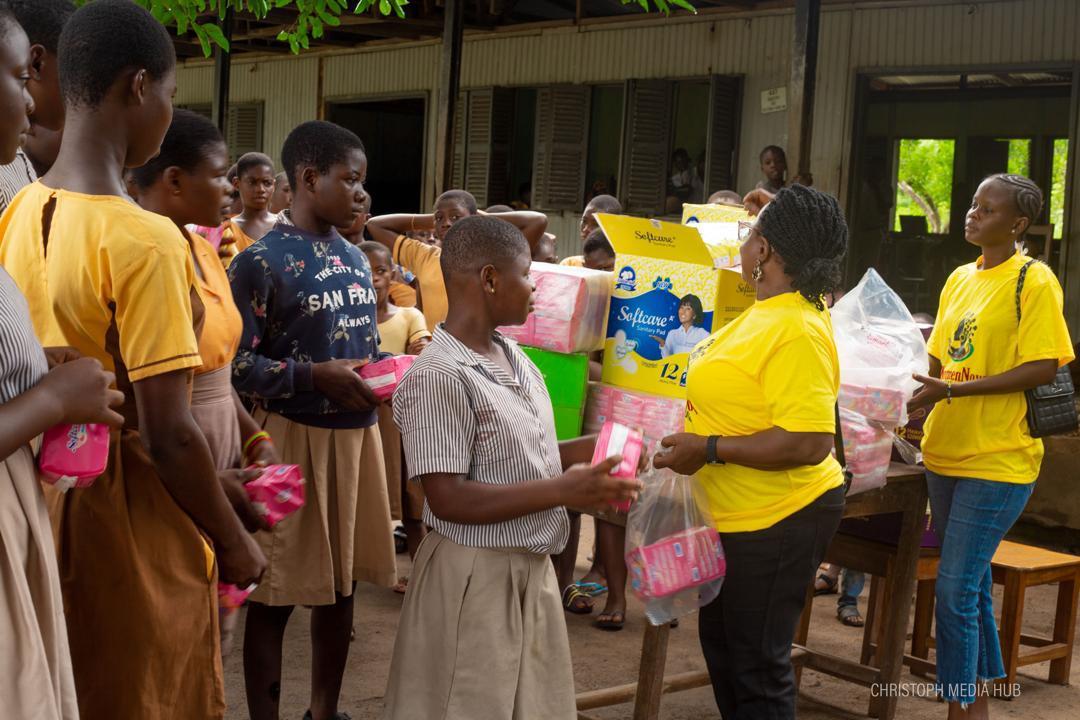 WomenNow volunteers distributing packs of pads to students at school